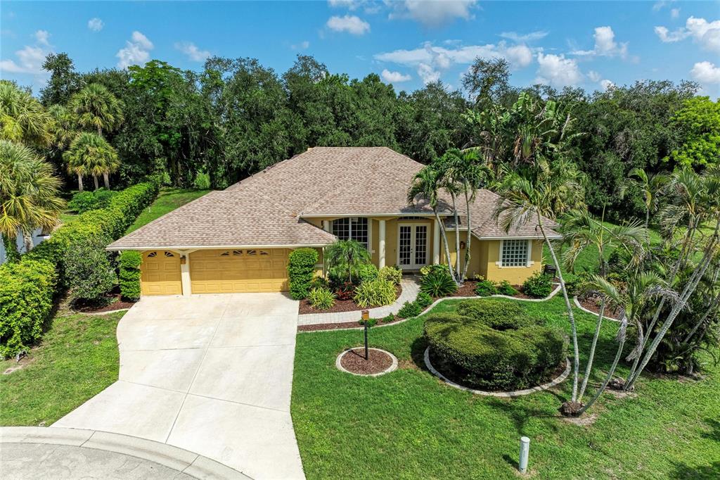 A swimming pool with a rock waterfall feature is enclosed by a screened lanai — 6401 KYLIE CREEK WAY, SARASOTA, FL