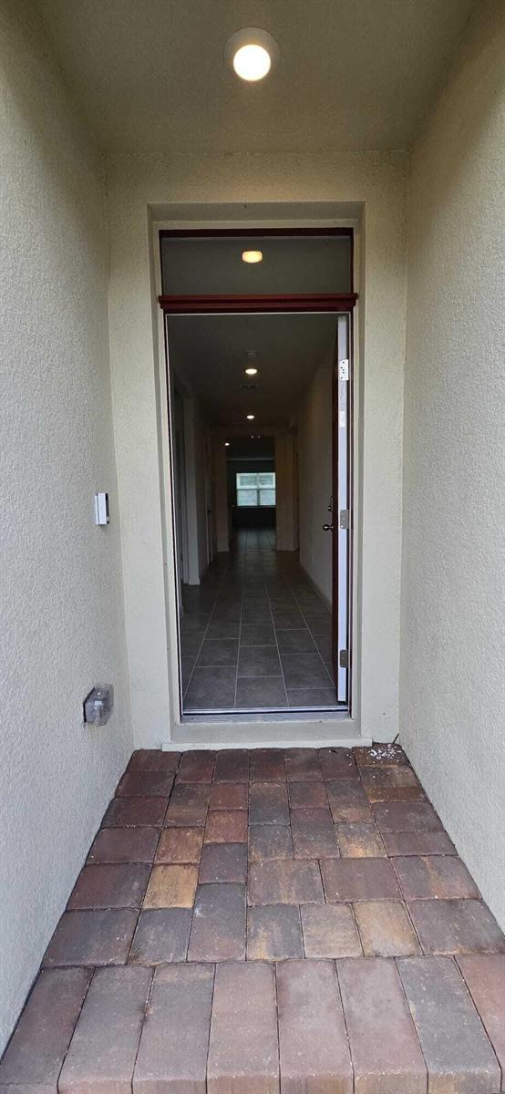 A view from a paved entryway looking through an open front door into a hallway — 528 Seafoam Circle, Fort Pierce FL 34945, FORT PIERCE, FL