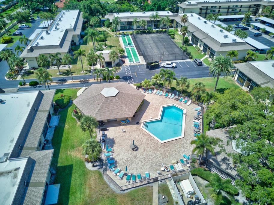 An aerial view shows a community pool, clubhouse, shuffleboard court, and surrounding apartment buildings — 12300 VONN ROAD UNIT 4307, LARGO, FL