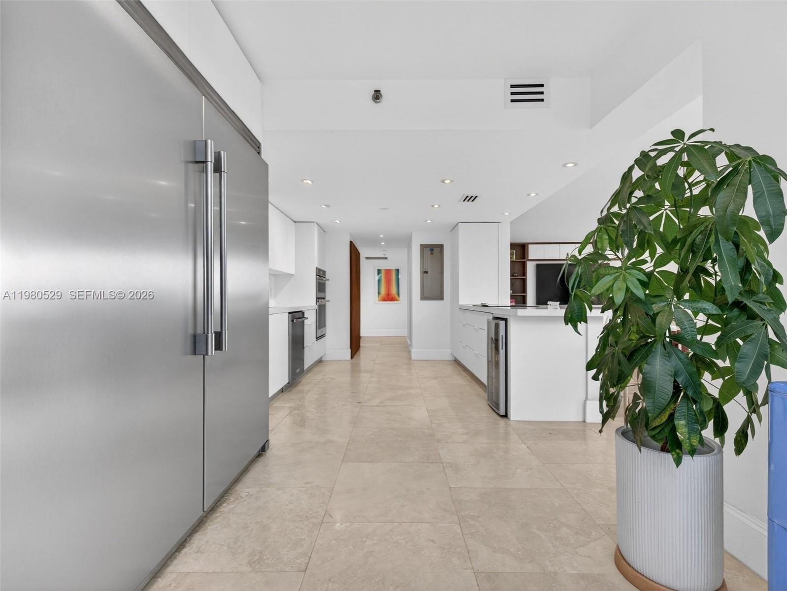 A modern kitchen features stainless steel appliances, white cabinetry, and light-colored tile flooring — 11113 Biscayne Blvd # 351, Miami FL 33181, MIAMI, FL