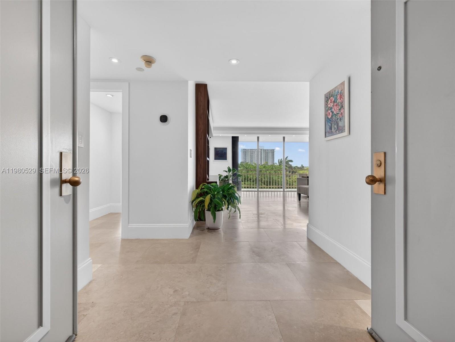 A bright entryway with tile floors leads to a living area with a balcony view — 11113 Biscayne Blvd # 351, Miami FL 33181, MIAMI, FL