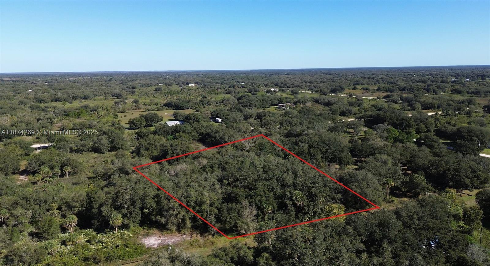 An aerial view shows a rectangular plot of land outlined in red amidst dense trees — 21229 NW 252 Street, Okeechobee FL 34972, OKEECHOBEE, FL