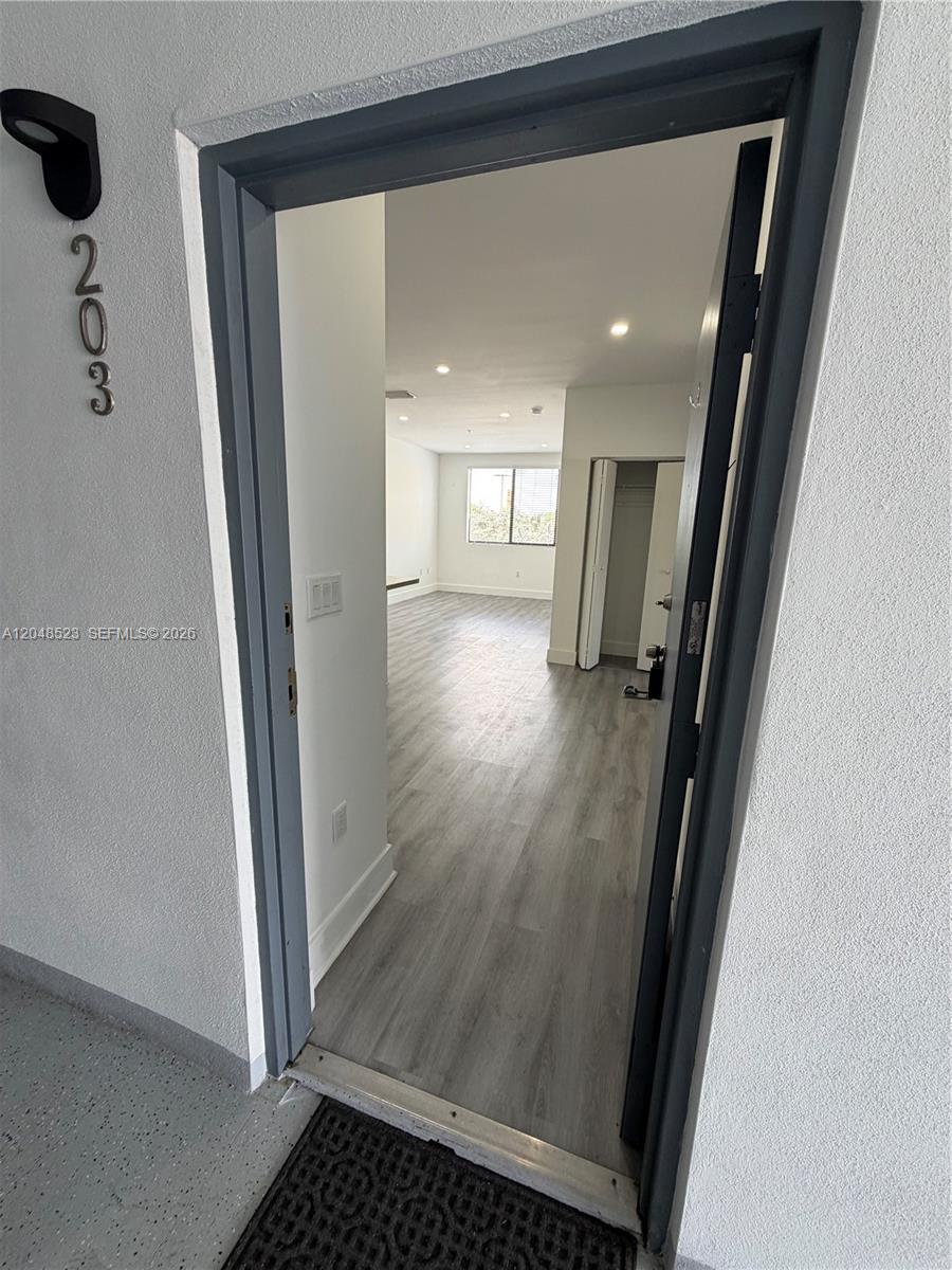 A view through an open doorway into an apartment with light wood-look flooring — 853 E 24th St # 403, Hialeah FL 33013, HIALEAH, FL