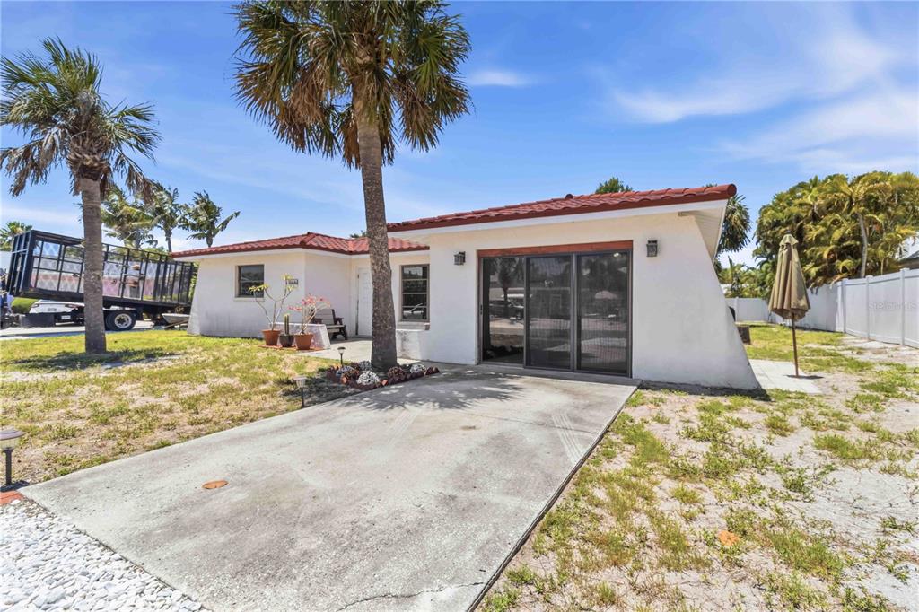 A white house with a red tile roof and a concrete driveway under a palm tree — 306 PALM AVENUE, ANNA MARIA, FL