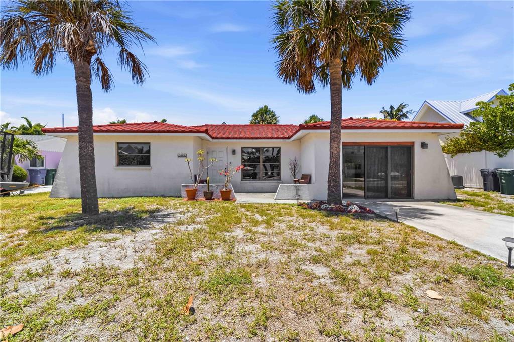 A single-story house with a red tile roof, white stucco walls, and two palm trees — 306 PALM AVENUE, ANNA MARIA, FL