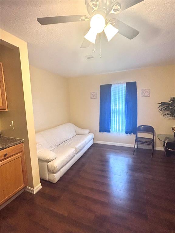 A living room features a white sofa, dark wood flooring, and a ceiling fan — 1513 N CENTRAL AVENUE, KISSIMMEE, FL
