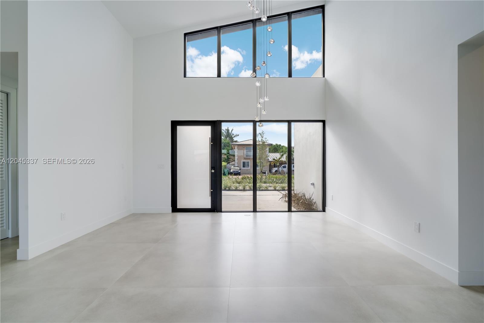 A spacious open-concept living area features high ceilings, light tile floors, and a modern kitchen — 4321 SW 99th Ave, Miami FL 33165, MIAMI, FL