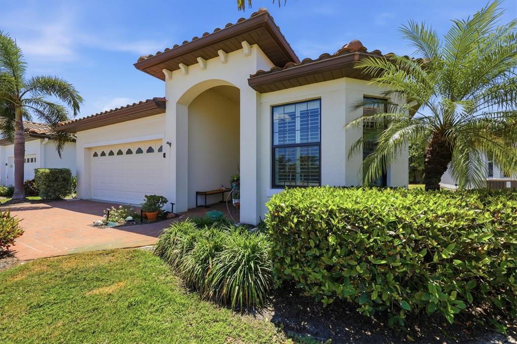 A single-story house with a beige stucco exterior, a tile roof, and a paved driveway — 175 NOLEN DRIVE, VENICE, FL