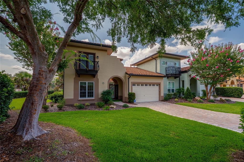 A two-story stucco house with a tile roof, a two-car garage, and two wrought-iron balconies — 1259 AVENIDA DE LAS CASAS, LADY LAKE, FL