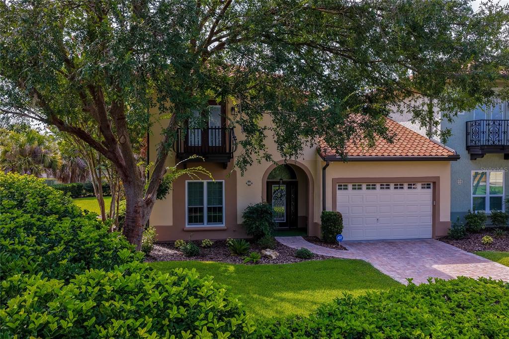A two-story house with a beige stucco exterior, a tiled roof, and a single-car garage — 1259 AVENIDA DE LAS CASAS, LADY LAKE, FL