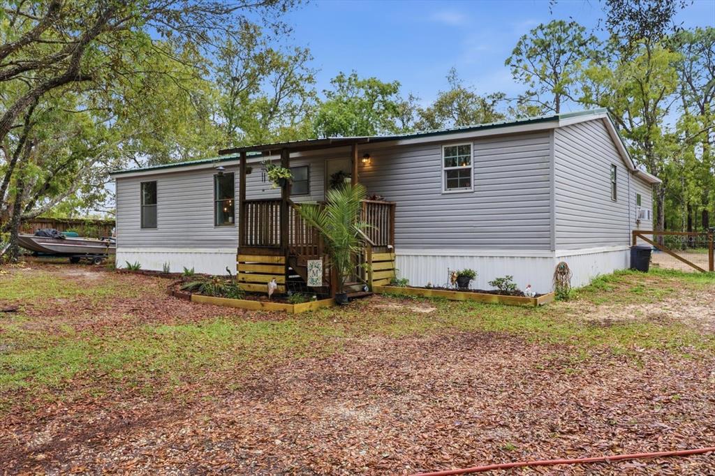 A single-story manufactured home with grey siding and a wooden front porch — 5114 W ROCHELLE STREET, HOMOSASSA, FL