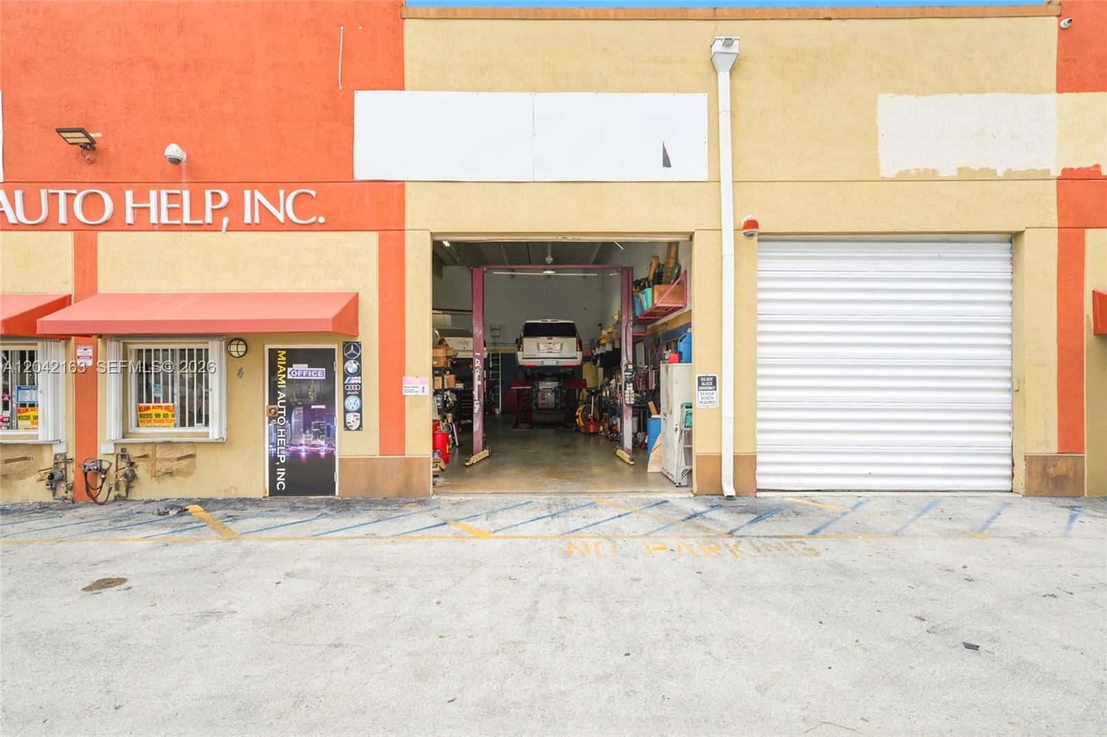 The exterior of an auto repair shop features a garage bay and office entrance — 11951 SW 144th Ct, Miami FL 33186, MIAMI, FL