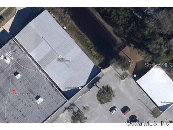 This is an aerial satellite view of a commercial building and its parking lot — 1927 SW COLLEGE ROAD UNIT C, OCALA, FL