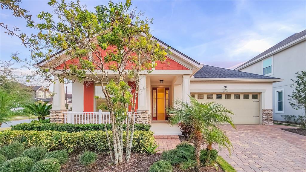 A single-story house features a red-accented front porch, a paved driveway, and a two-car garage — 8201 CORKFIELD AVENUE, ORLANDO, FL