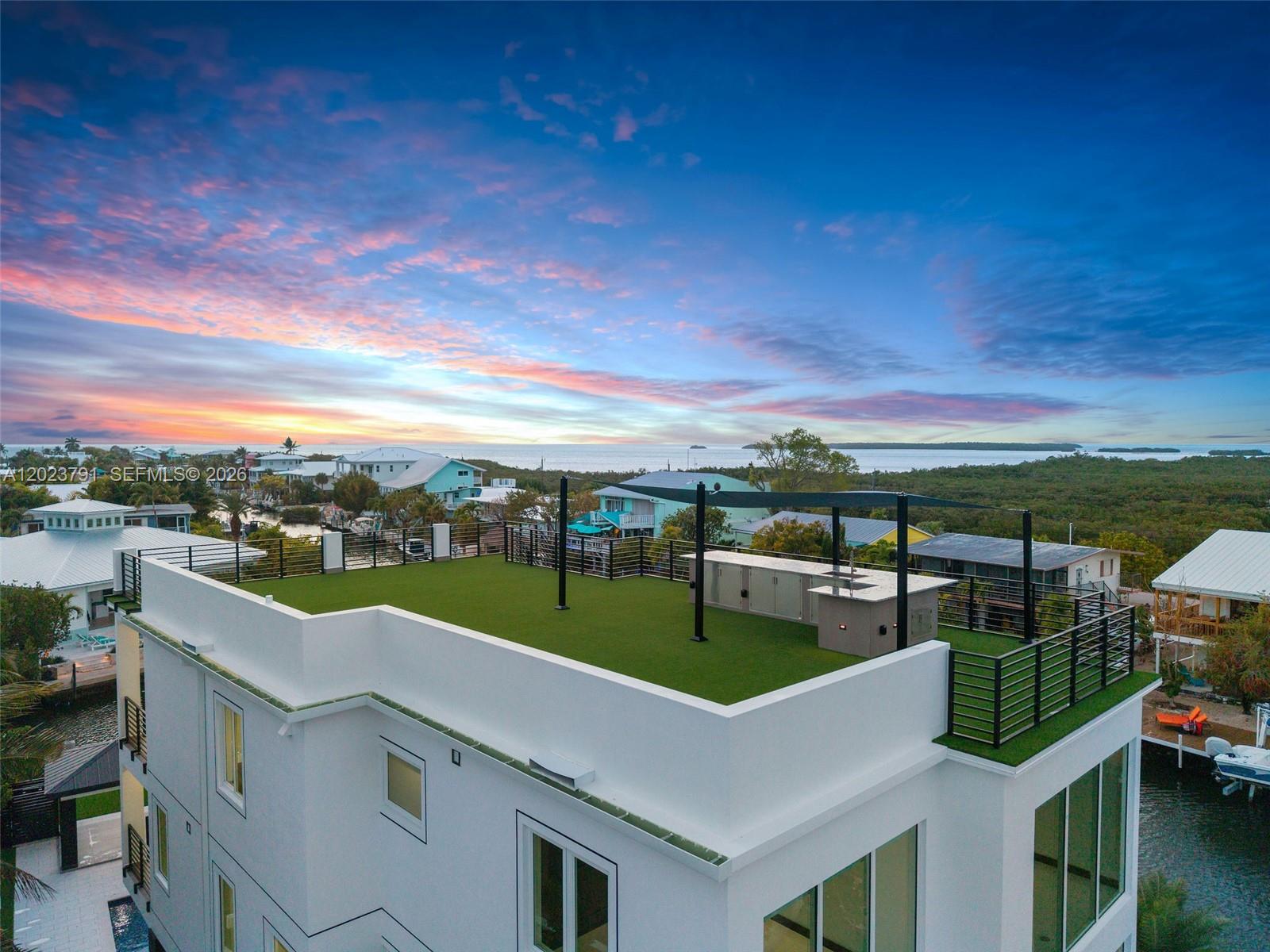 An aerial view of a rooftop terrace featuring artificial turf, a kitchen island, and railings — 265 Pueblo St, Tavernier FL 33070, TAVERNIER, FL