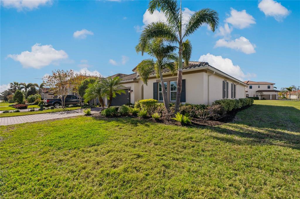 A single-story suburban house with a palm tree, a paved driveway, and a grassy lawn — 4604 TOBERMORY WAY, BRADENTON, FL