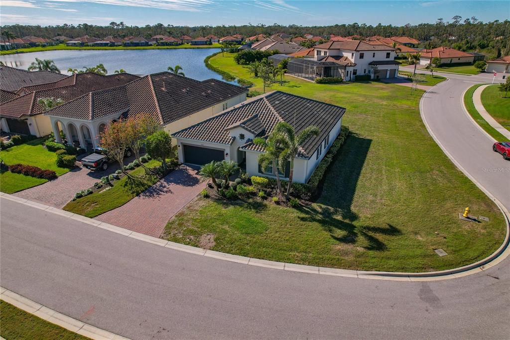 An aerial view shows a suburban house with a tiled roof and brick driveway — 4604 TOBERMORY WAY, BRADENTON, FL
