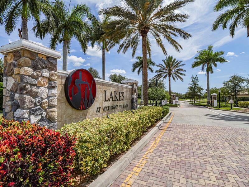A stone and stucco entrance sign for Lakes at Waterway Village with palm trees — VERO BEACH, FL