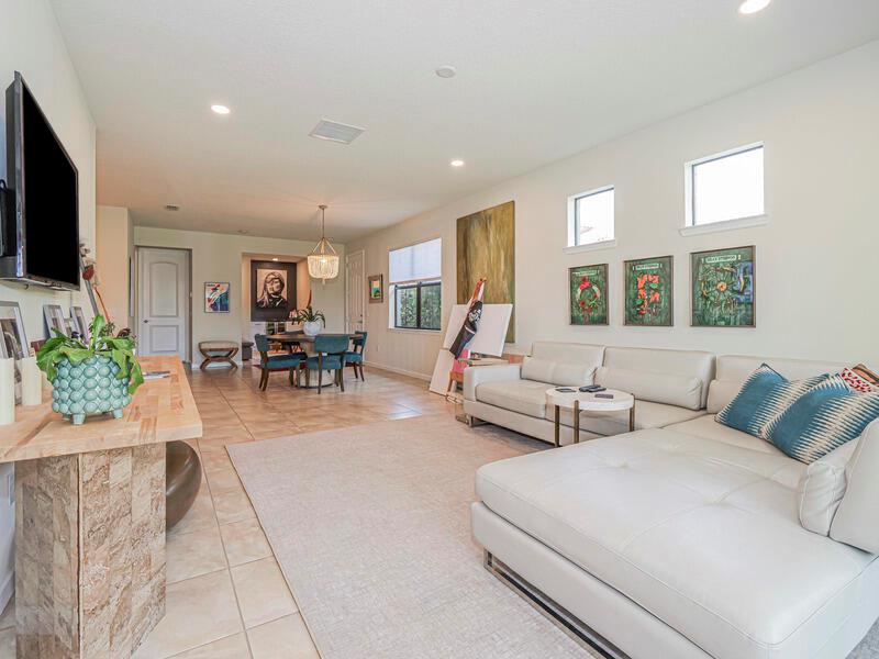 A living room with a white sectional sofa, tile flooring, and an adjacent dining area — VERO BEACH, FL