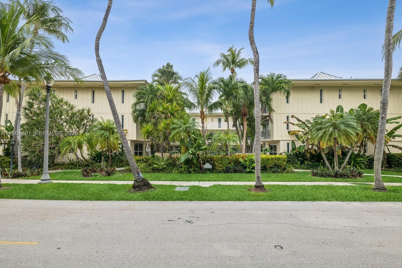 A multi-story apartment building is surrounded by lush tropical landscaping and tall palm trees — 255 Sunrise Dr # 107, Key Biscayne FL 33149, KEY BISCAYNE, FL