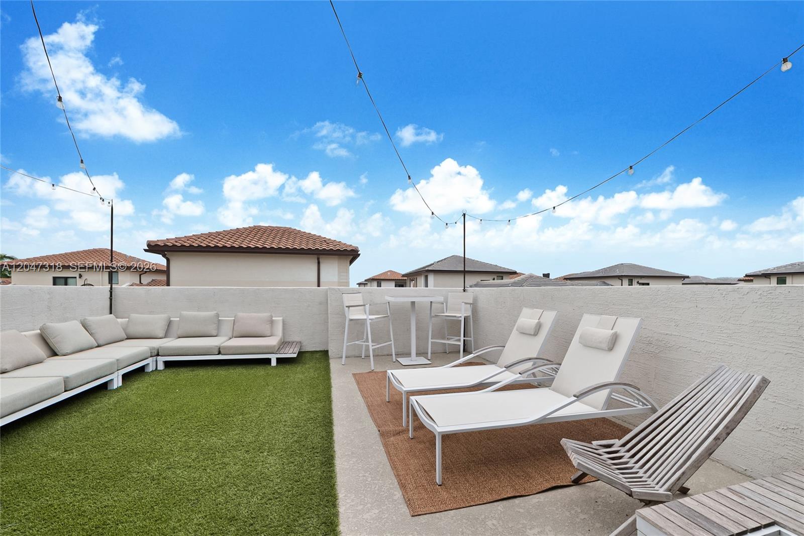 A rooftop terrace features artificial turf, lounge chairs, a dining set, and string lights — 4605 NW 83rd Path, Doral FL 33166, DORAL, FL