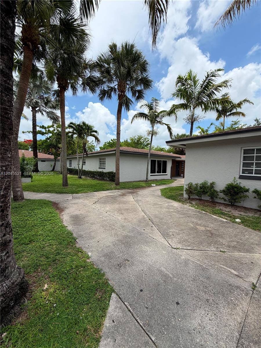 A concrete driveway leads to the exterior of a single-story house with palm trees — 2551 NW 26th St, Sunrise FL 33313, SUNRISE, FL