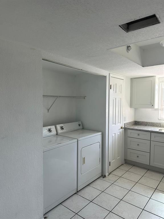 A laundry area features white appliances, a wire shelf, and tiled flooring in a kitchen — 2409 BARLEY CLUB DRIVE UNIT 3, ORLANDO, FL