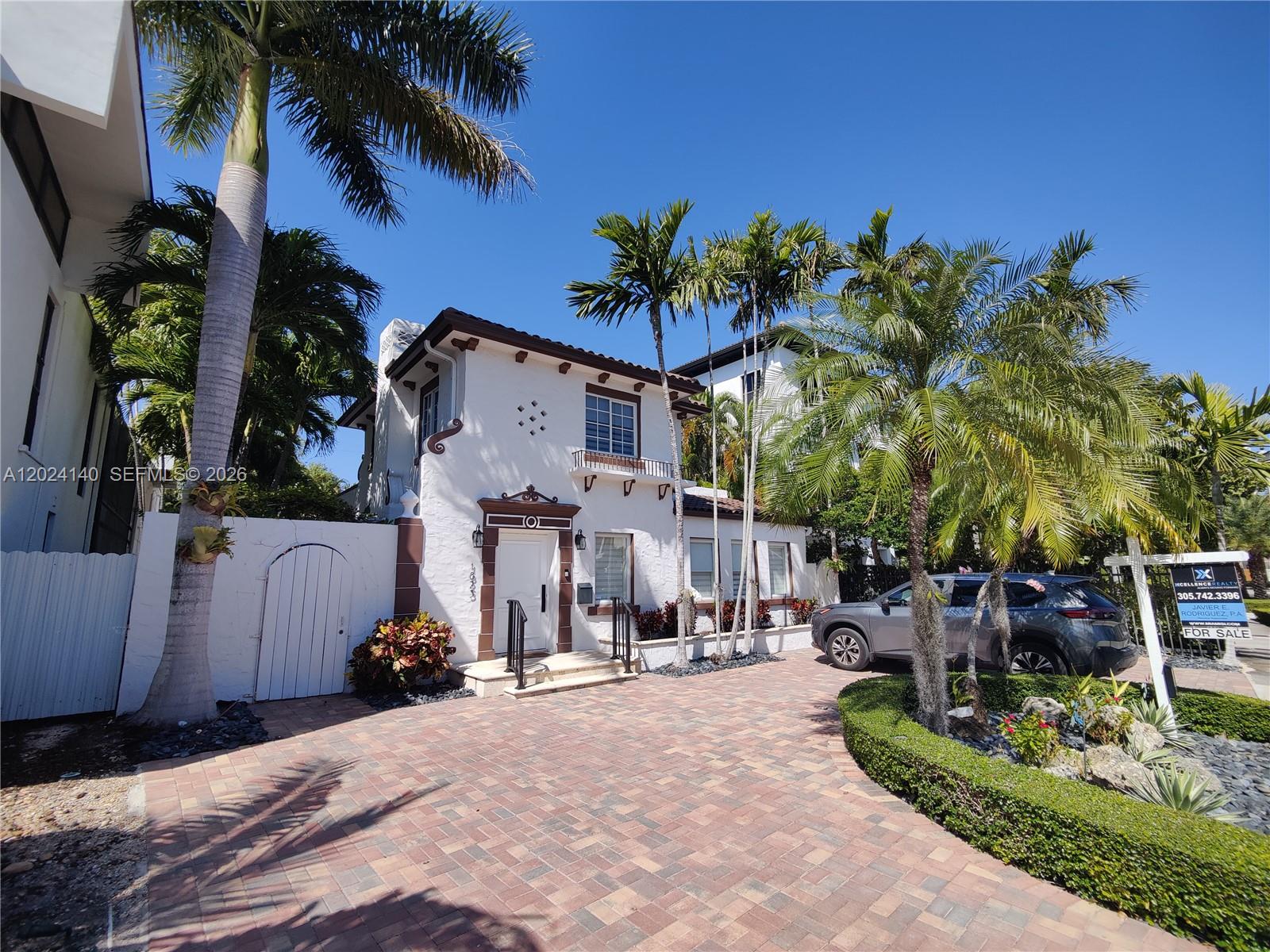 A two-story white stucco house features a brick driveway, palm trees, and a for-sale sign — 1823 S Bayshore Ln # 0, Miami FL 33133, MIAMI, FL