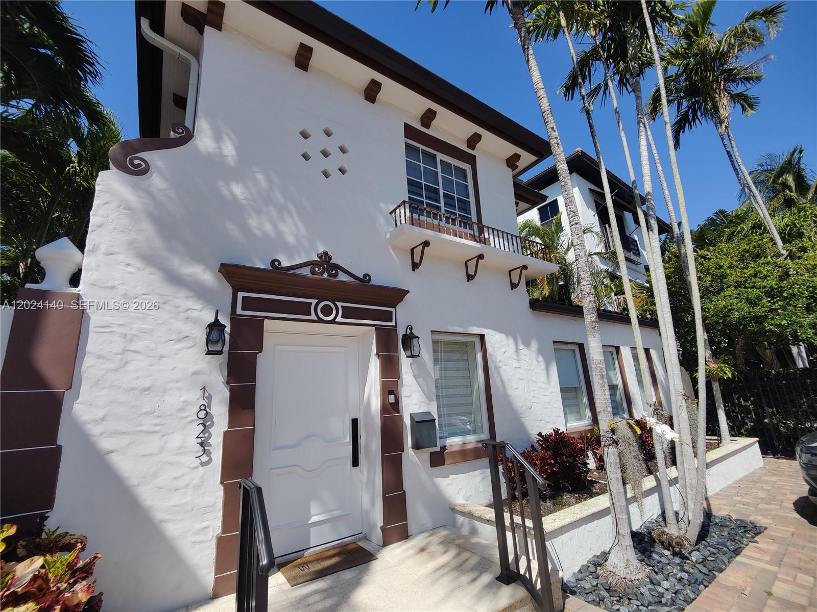 A white stucco two-story building features brown trim, a front door, and palm trees — 1823 S Bayshore Ln # 0, Miami FL 33133, MIAMI, FL