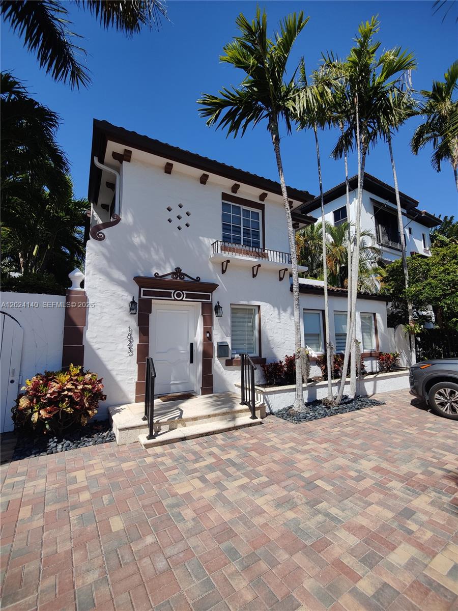 A two-story white stucco house features brown trim, a tiled driveway, and tall palm trees — 1823 S Bayshore Ln # 0, Miami FL 33133, MIAMI, FL