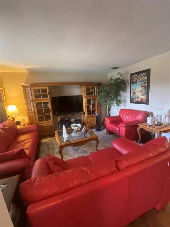 A living room features red leather sofas, a wooden entertainment center, and a coffee table — 1657 N NORMANDY BOULEVARD, DELTONA, FL
