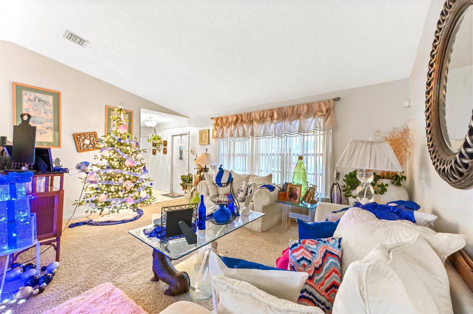 A living room features a decorated Christmas tree, white sofas, and a glass coffee table — 2531 Doral Way, Riviera Beach FL 33407, RIVIERA BEACH, FL