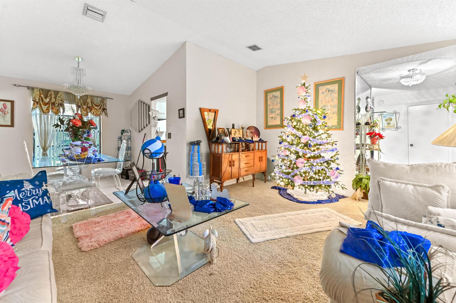 A living room features a decorated Christmas tree, a glass coffee table, and carpeted flooring — 2531 Doral Way, Riviera Beach FL 33407, RIVIERA BEACH, FL
