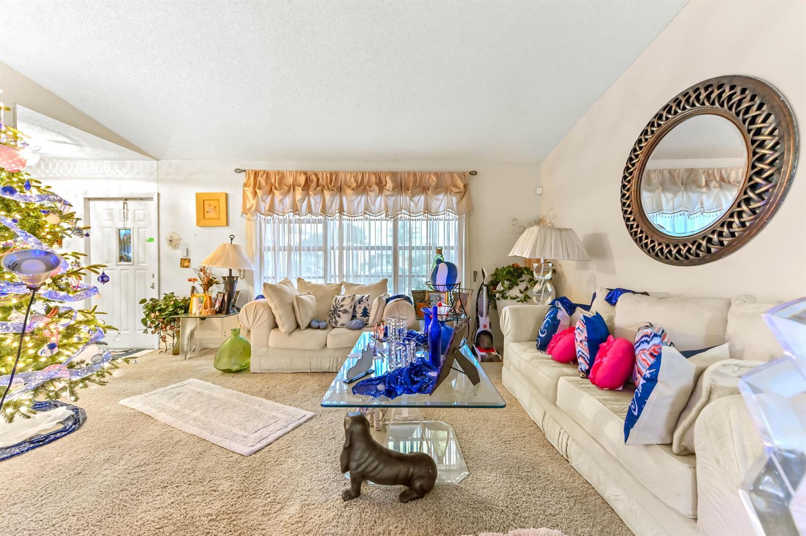 A living room features a Christmas tree, two beige sofas, and a glass coffee table — 2531 Doral Way, Riviera Beach FL 33407, RIVIERA BEACH, FL