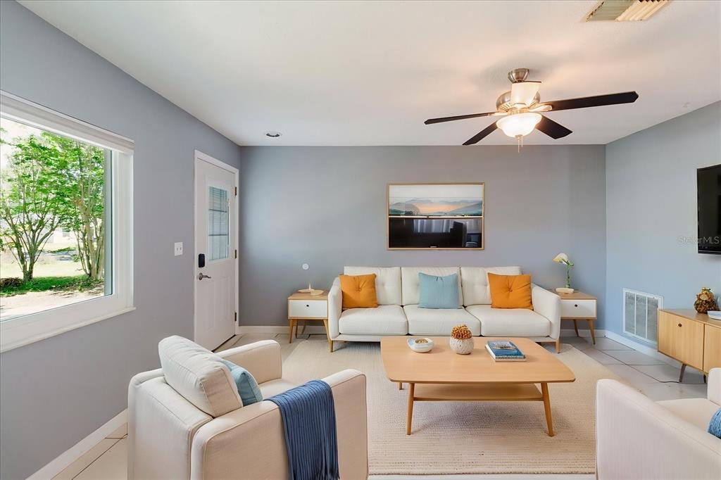 A living room features a light blue sofa, a wooden coffee table, and tile flooring — 2009 PEPPERTREE COURT, OLDSMAR, FL