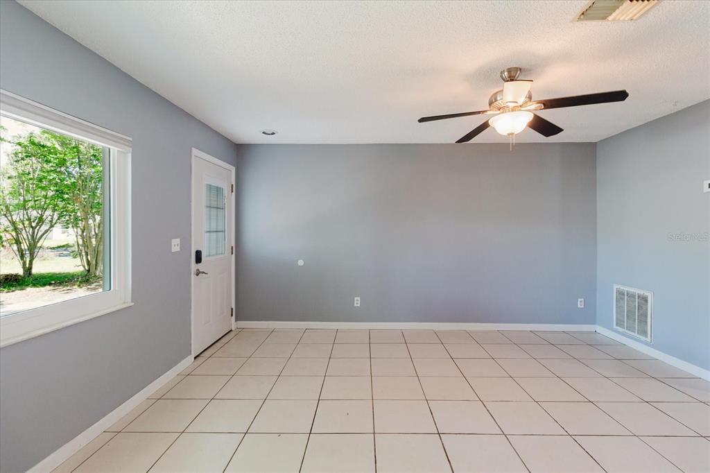 A living room features a light gray sofa, matching armchair, round coffee table, and area rug — 2009 PEPPERTREE COURT, OLDSMAR, FL