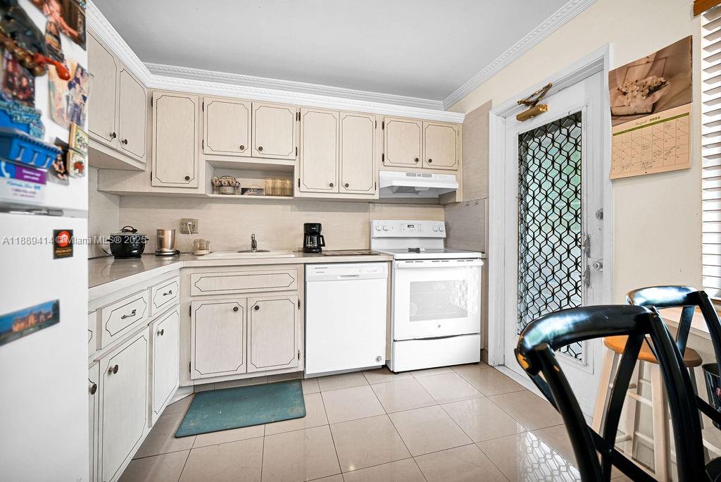 A kitchen features white cabinets, white appliances, tiled flooring, and a glass-paned exterior door — 4800 Hillcrest Ln # 210, Hollywood FL 33021, HOLLYWOOD, FL