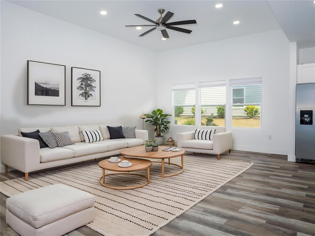 A modern living room features a white sofa, two round coffee tables, and wood-look flooring — 217 SW 246TH WAY, NEWBERRY, FL