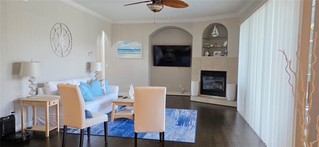 A living room features a sofa, two chairs, a fireplace, and a blue area rug — 10021 HART BRANCH CIRCLE, ORLANDO, FL