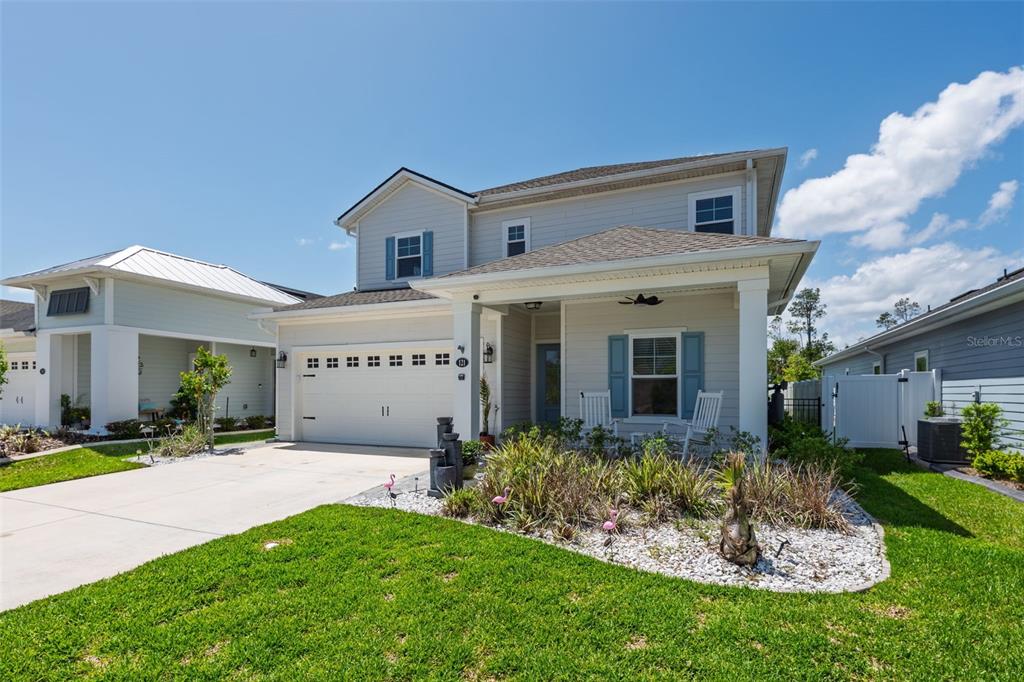 A two-story house with light siding, a front porch, and a two-car garage — 121 NIGHTHAWK LANE, PALM COAST, FL