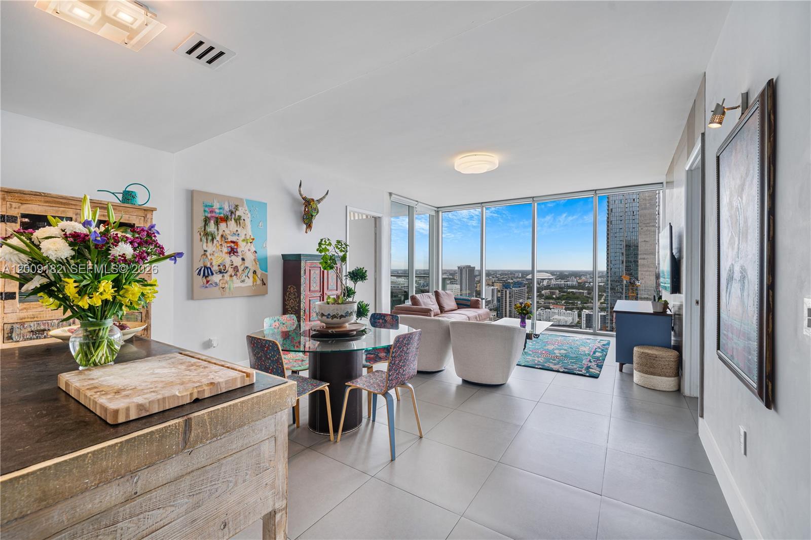 A modern open-concept living and dining area features floor-to-ceiling windows with expansive city views — 1040 Biscayne Blvd # 3607, Miami FL 33132, MIAMI, FL