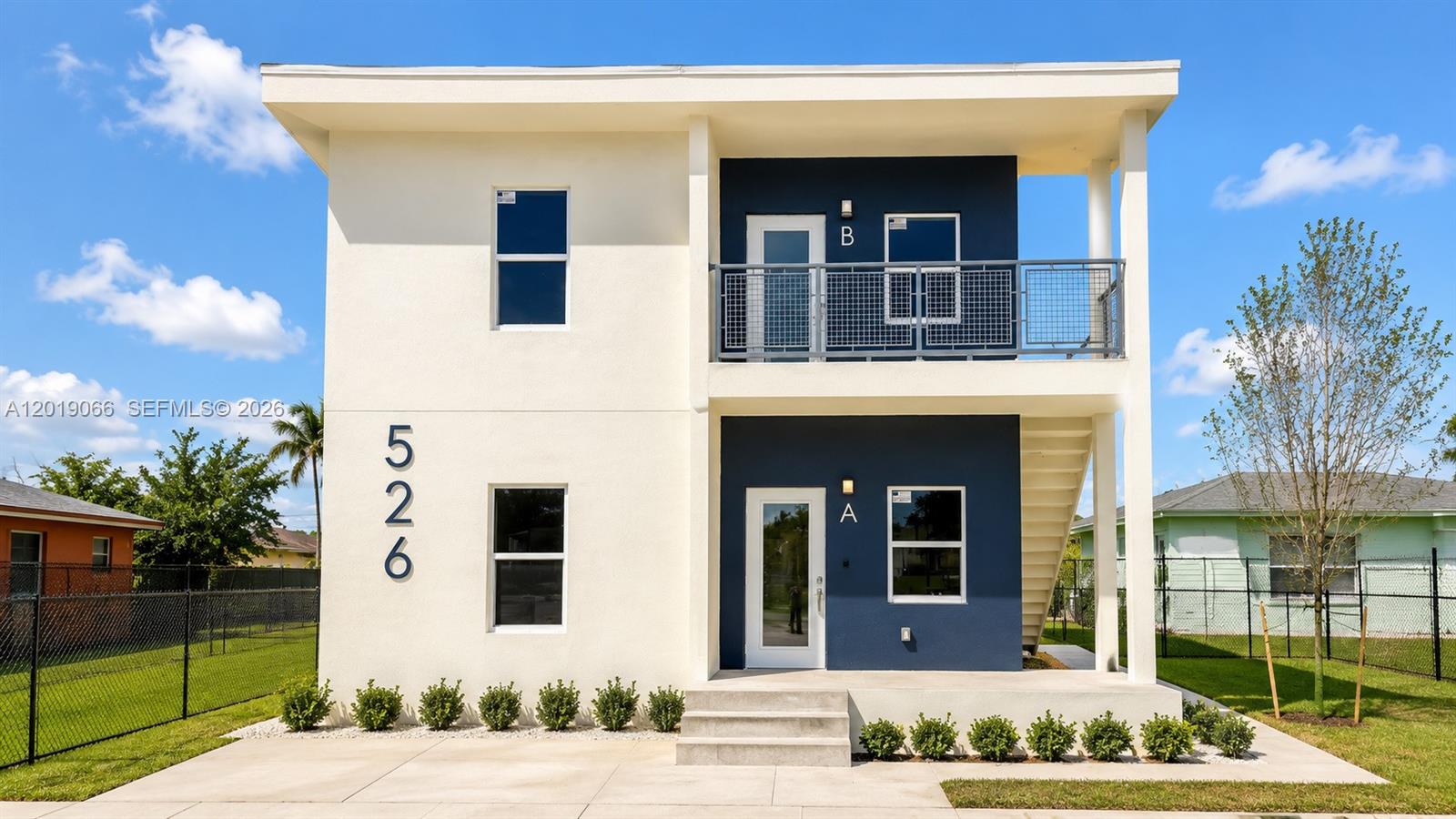 A two-story duplex building with white and blue exterior walls and a front staircase — 526 NW 6th St, Hallandale Beach FL 33009, HALLANDALE BEACH, FL