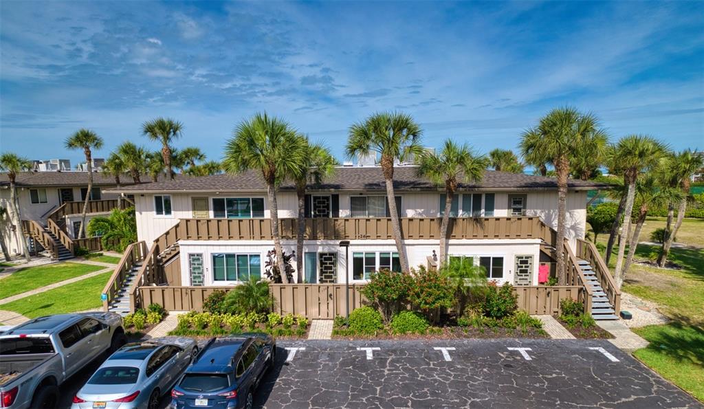 An exterior view of a two-story apartment building with palm trees and a parking lot — 6701 GULF OF MEXICO DRIVE UNIT 332, LONGBOAT KEY, FL