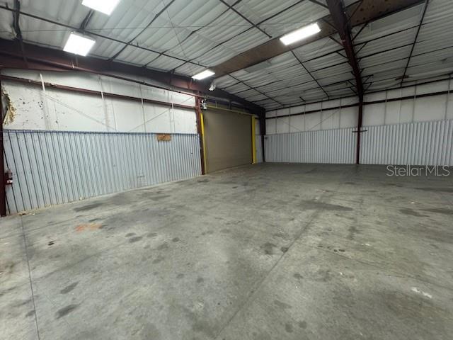 An empty industrial warehouse space features concrete floors, metal walls, and overhead lighting — 2251 TOPLINE WAY UNIT 5, BROOKSVILLE, FL