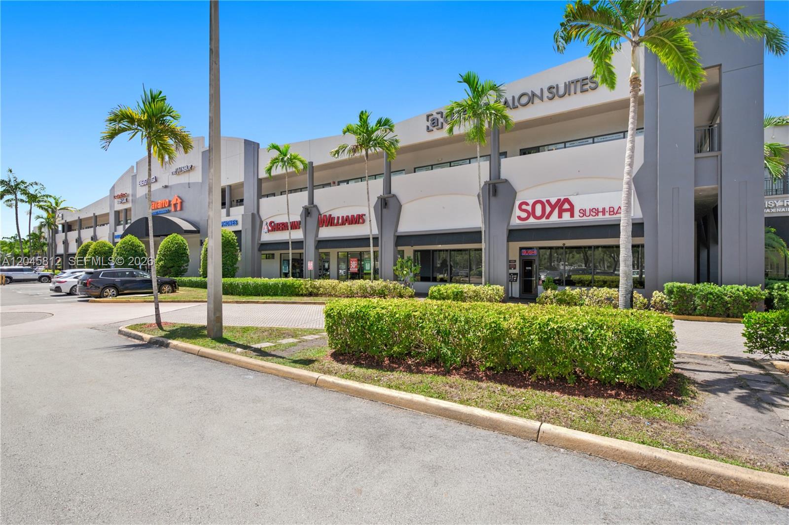 A multi-story commercial shopping center features a row of storefronts with palm trees in front — 11402 NW 41st St # 207, Doral FL 33178, DORAL, FL