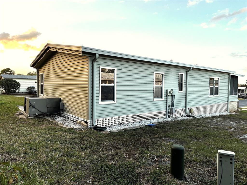 An aerial view shows a residential neighborhood of mobile homes near a large body of water — 168 BEECHWOOD DRIVE UNIT 67, SAFETY HARBOR, FL