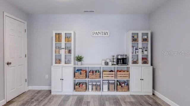 A pantry area features white cabinets with glass-front upper doors and open shelving with storage baskets — 732 AVONDALE AVENUE, DAYTONA BEACH, FL