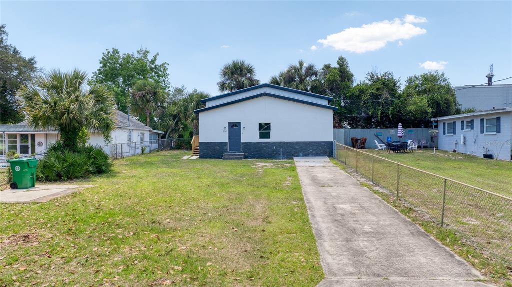 A single-story house with a white facade and stone base features a concrete driveway — 732 AVONDALE AVENUE, DAYTONA BEACH, FL
