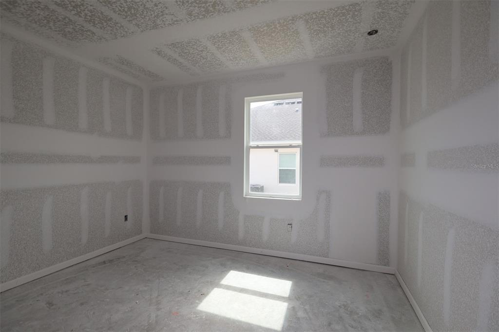 A modern kitchen features white cabinets, a large island with a sink, and stainless appliances — 3206 WOLF LAKE AVENUE, APOPKA, FL