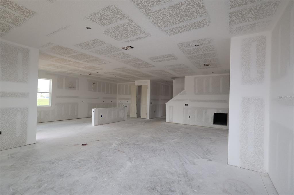 A modern kitchen features white cabinetry, a central island with a sink, and tile flooring — 3206 WOLF LAKE AVENUE, APOPKA, FL